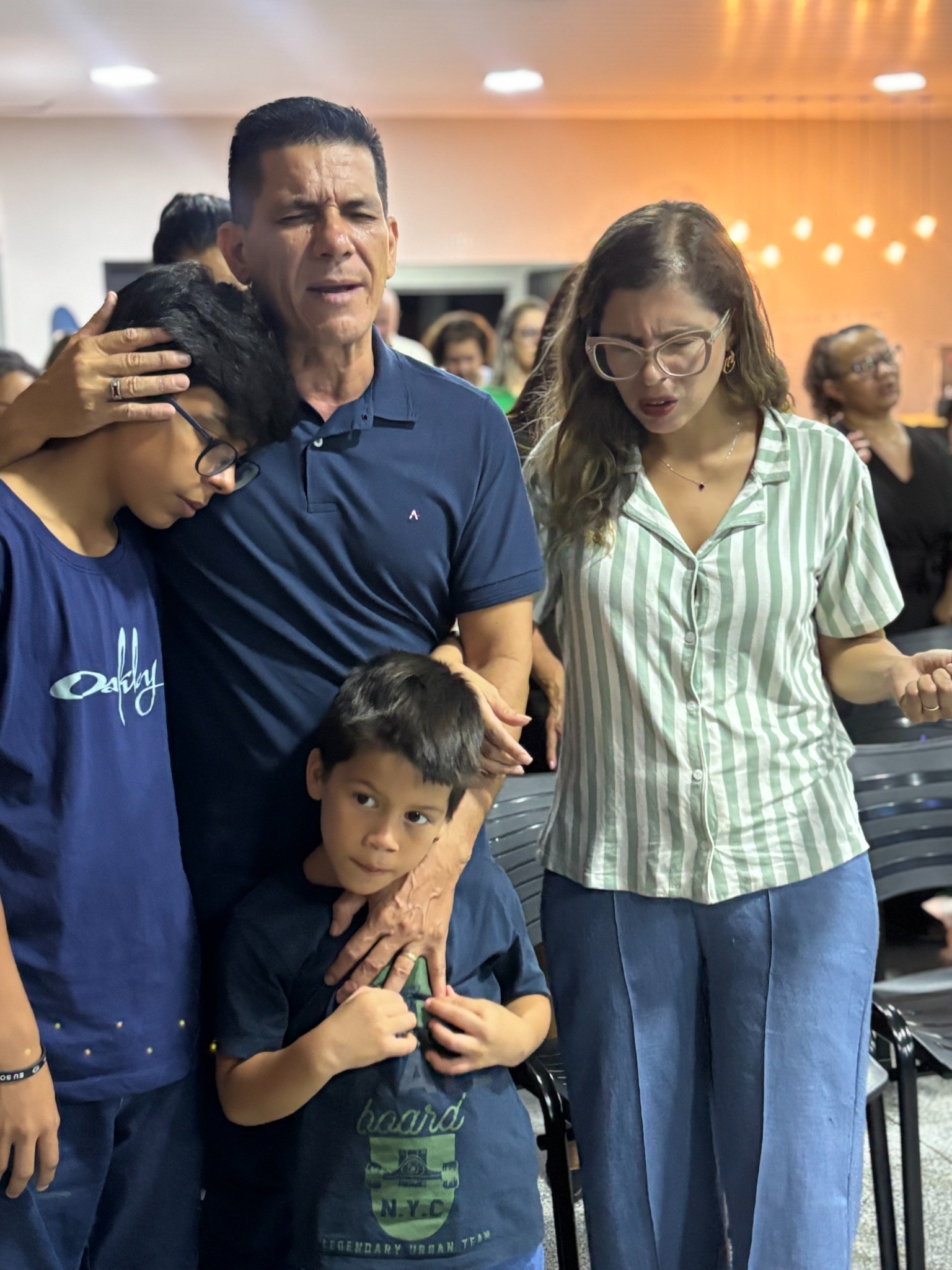 Bispo Rivelino e Pastora Mirella com as crianças em um momento de oração